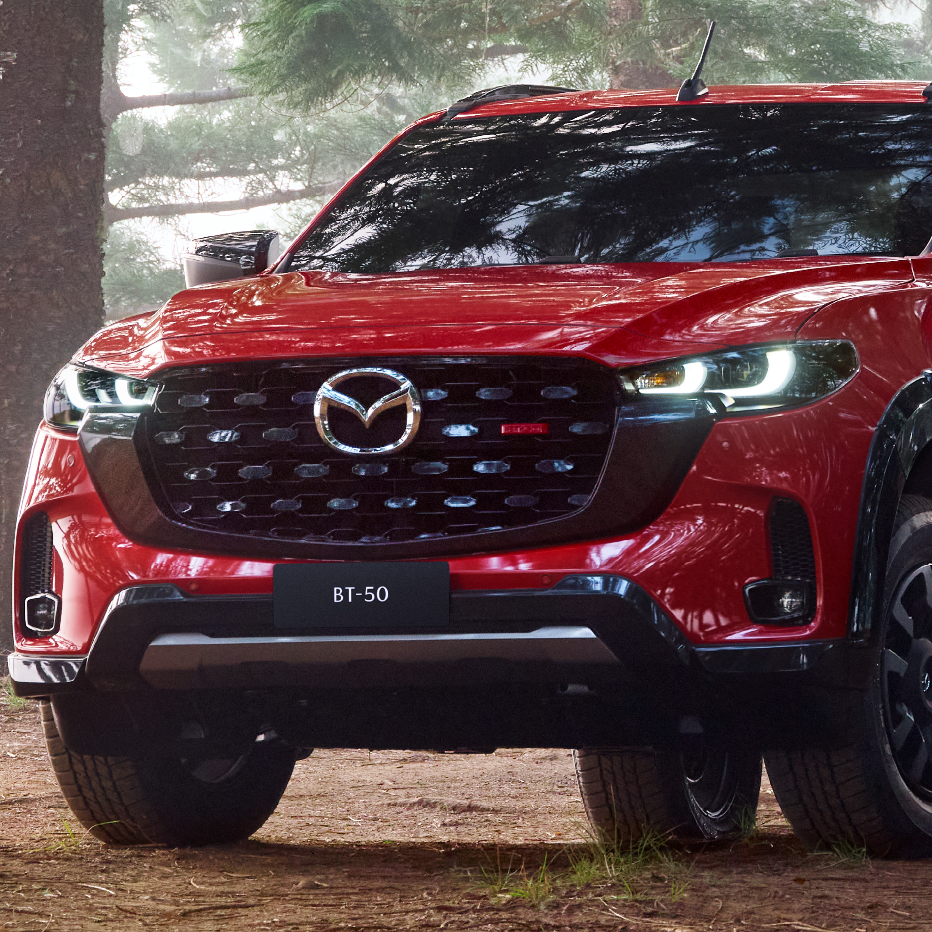 Vista frontal de la Mazda BT-50 2025 roja, con parrilla imponente, luces LED y diseño musculoso.