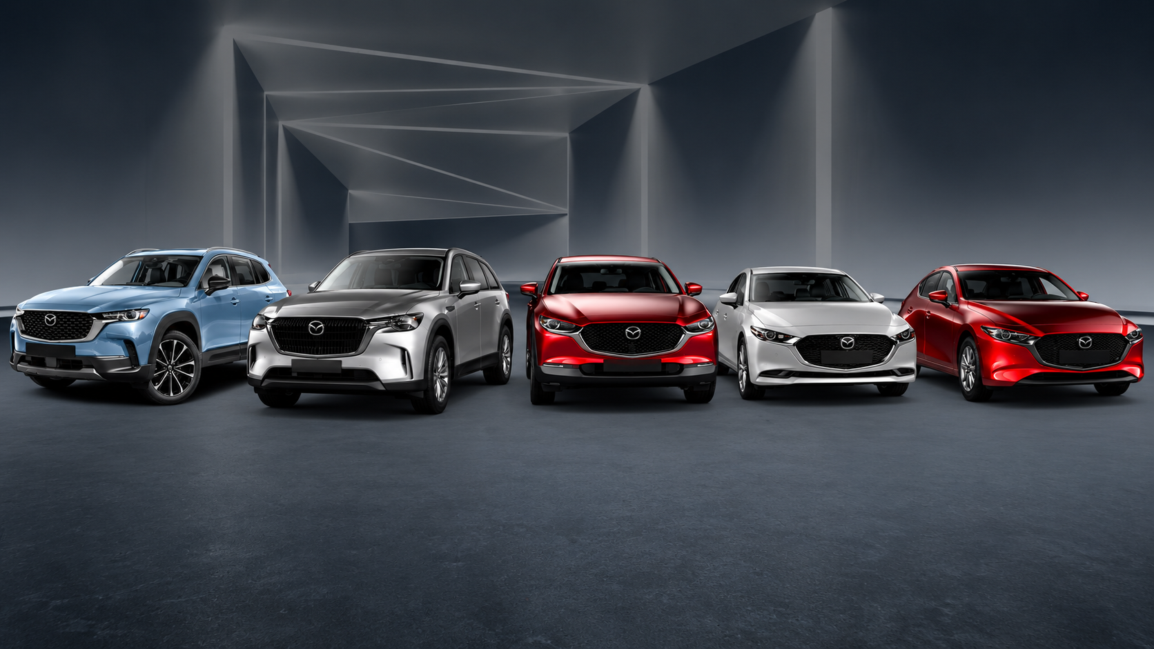 Varios vehículos Mazda de distintos modelos y colores alineados en un espacio de exhibición.